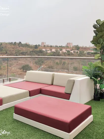 The modular outdoor sofa on the "Project 22 Days" terrace. The bright magenta cushions add a pop of color against the artificial turf, making the space feel vibrant and fun.