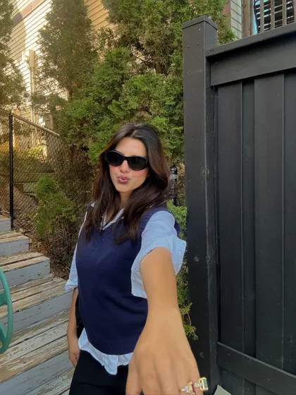 A playful, reaching-for-the-camera shot in my casual sweater vest outfit.