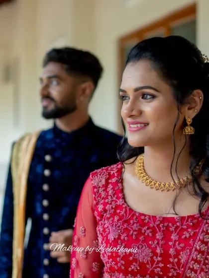 A candid shot of the couple. The bride's side profile shows off her elegant half-up hairstyle and the flawless finish of her makeup.