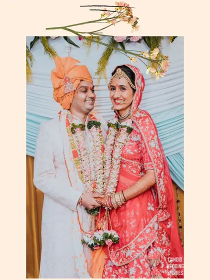 A classic portrait of the couple after their Varmala exchange, holding hands and smiling, dressed in beautiful traditional attire.