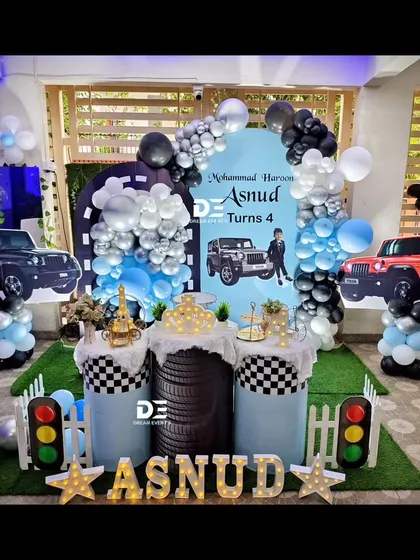 A rugged and cool Thar-themed party for Asnud's 4th birthday. The setup features cutouts of the popular jeep, a tire-themed pedestal, and a stylish black, silver, and blue color scheme.