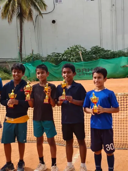 A group of our young champions holding their trophies. Seeing our players succeed together is what our tennis family is all about.