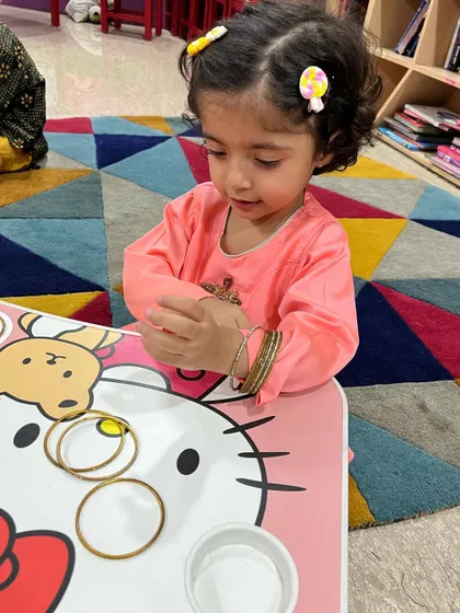 Even the littlest hands get busy during our Diwali craft session. This little girl is exploring bangles and colours.
