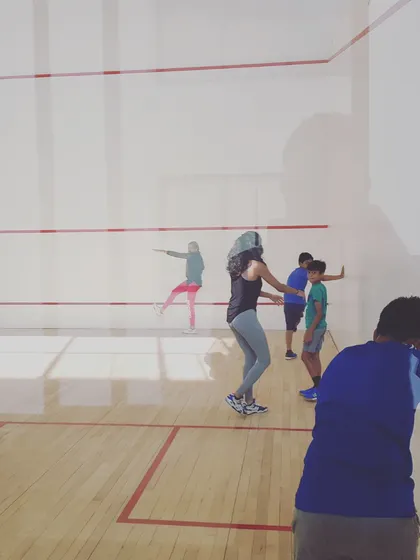 A coach demonstrates proper body rotation and swing follow-through to a small group of students. Visual learning is a powerful tool we use in our technical sessions.