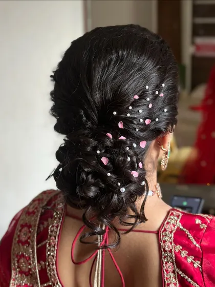 A soft and romantic messy updo, perfect for a reception or sangeet. I've added delicate pink petals and pearls to give it a dreamy, whimsical feel.