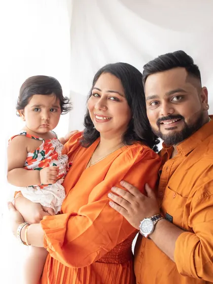 A bright and happy family portrait. The coordinated orange outfits bring so much warmth and energy to this photo, celebrating their daughter's birthday.