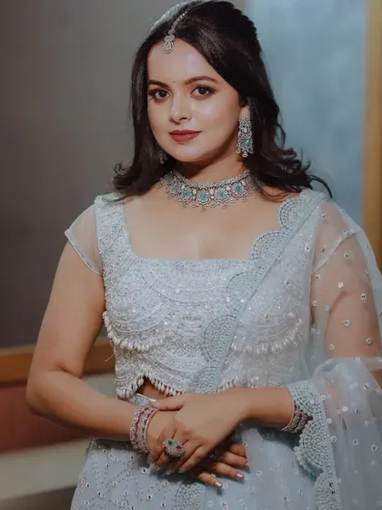 A beautiful portrait of a woman in a powder blue lehenga, showcasing her elegant diamond jewelry set.