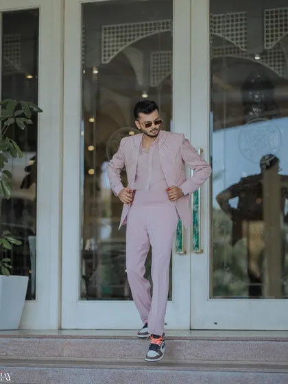 The groom looking sharp as he walks out of a building, ready for the Haldi carnival.