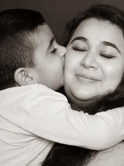 A sweet kiss on the cheek is a simple gesture filled with immense love. I aim to capture these tender interactions that highlight the special bond between a mother and her son.