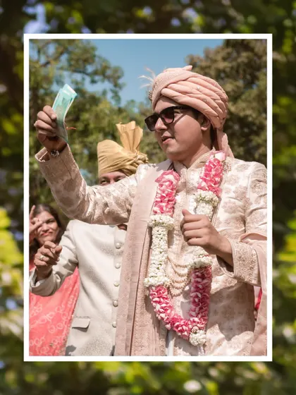 A framed portrait of the groom during the Baraat, holding up a banknote. This is a classic, fun moment from the groom's procession.