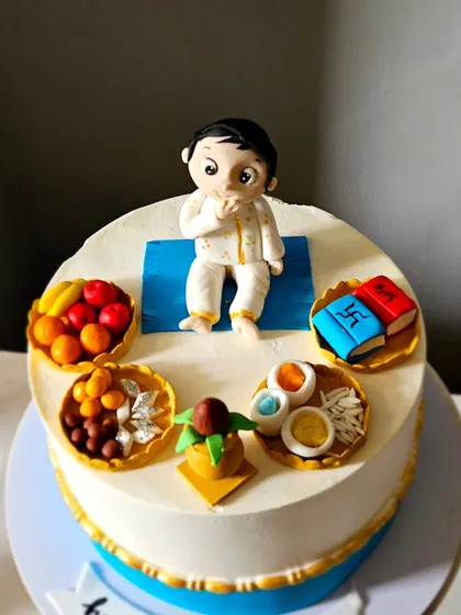 Another angle of the Annaprasan cake, highlighting the handcrafted details of the ceremonial items.