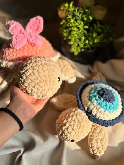 Holding our butterfly and evil eye turtles. The chunky yarn gives them a substantial, comforting weight, and the unique designs make them great conversation starters.