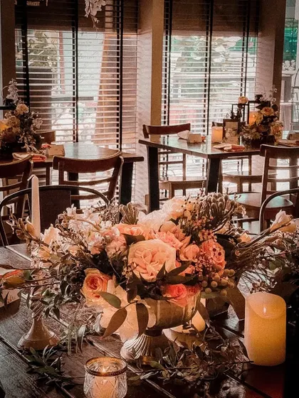 This image shows a detailed floral centerpiece I created for an event at a restaurant. I use lush, high-quality flowers and soft candlelight to transform a standard table into a focal point of beauty.