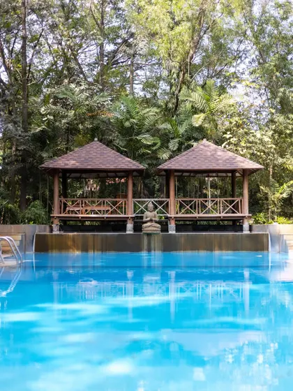 The serene setting of our swimming pool, complete with gazebos and lush greenery, makes it an ideal place to unwind and rejuvenate.