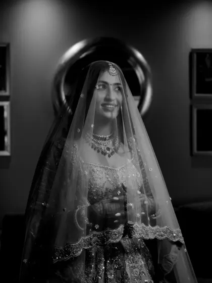 A classic black and white portrait of the bride, her face softly lit and her smile radiant under the veil.