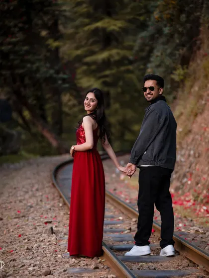 A classic "follow me" pose on the winding railway tracks, inviting the viewer into their journey together. This is a popular shot for pre-wedding couple photography.