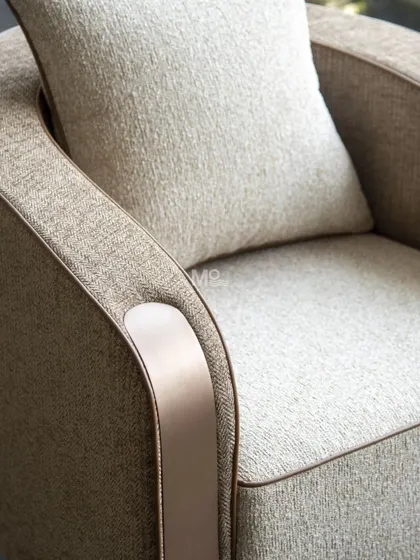 A detail of the Arcadia Swivel Armchair's armrest, showing the sleek metallic panel and refined piping. This highlights the meticulous craftsmanship that goes into every piece, perfect for a statement seating piece.