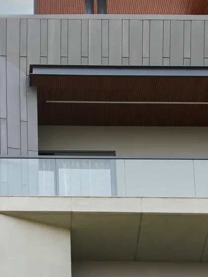 This close-up shows the material palette of the Akashneem Marg facade, with smooth concrete, textured panels, and wood-look ceilings creating a harmonious and modern look.