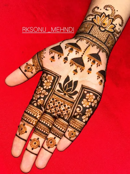 This design is a beautiful symphony of traditional Indian motifs. It features jhumka earrings, lotus flowers, and a central mandala, creating a different yet complementary look on each hand.