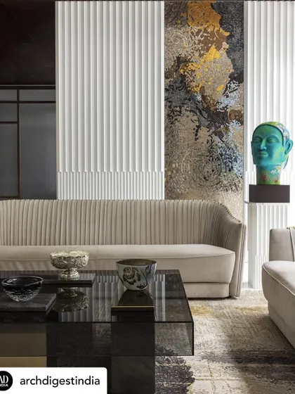 I love creating visual interest with layers. This living area features a soft, ribbed sofa against a backdrop of fluted wall panels and a stunning, abstract art piece. The composition of textures and colors makes the space feel both sophisticated and comfortable.