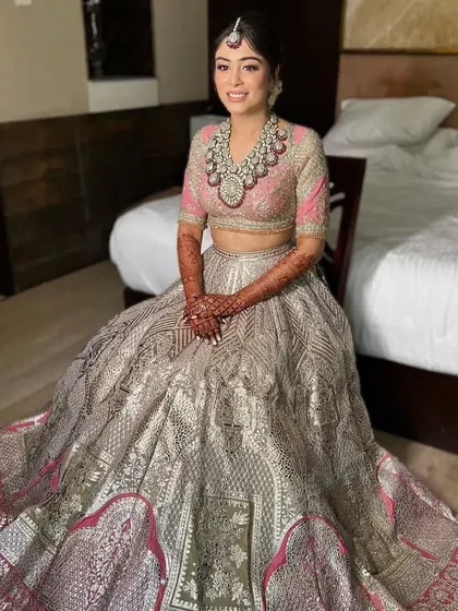 A full-length view of a bride with a soft updo, showing how the hairstyle complements her elaborate bridal gown. It's an elegant choice for a grand wedding.