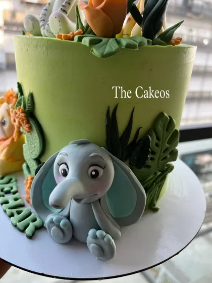 A close-up of the cute fondant elephant on the jungle-themed cake, showing its sweet expression.