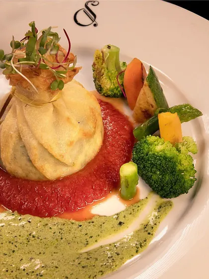 Crespella, a delicate Italian crepe filled with spinach and ricotta, served on a pool of tomato and pesto sauce. A beautiful and satisfying vegetarian main course.