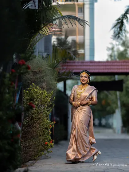 A full-length shot of a model in a beautiful, light-colored silk saree, perfect for a daytime muhurtham ceremony.