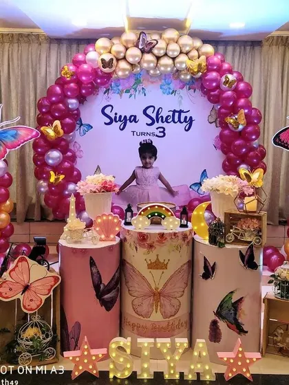 A vibrant butterfly-themed birthday for a three-year-old, using bold pinks and oranges.