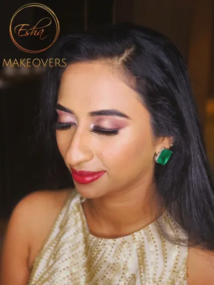 A chic cocktail look with a focus on glowing skin, a classic red lip, and statement emerald earrings. This is modern elegance at its best.