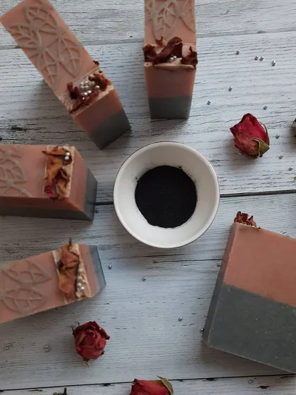 This is my Charcoal Rose soap, laid out with its core ingredients. It combines detoxifying activated charcoal and French pink clay with the beautiful scent of geranium and bergamot essential oils, making it perfect for all skin types, including oily skin.