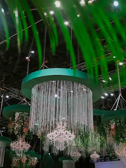 A view of the magnificent hanging chandeliers through lush green foliage, creating the feeling of discovering a secret, magical clearing in an enchanted forest.
