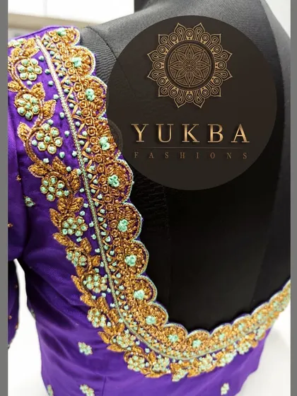 A side view of the purple scalloped blouse, providing a closer look at the intricate gold and mint-green embroidery that adorns the back and neckline.