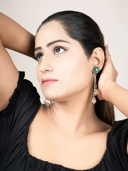A product-focused shot for a jewelry brand. The model's pose is designed to clearly display the earrings, making it an effective image for product listings or social media.