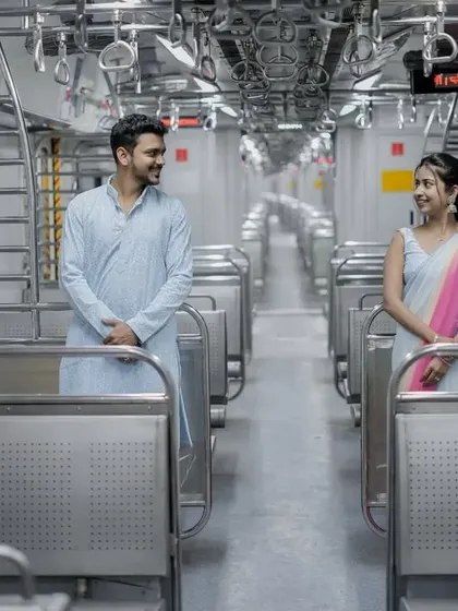 A creative shot inside an empty Mumbai local train, using the symmetry of the coach to frame the couple perfectly.