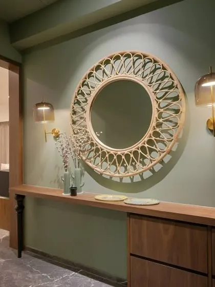 A simple yet elegant entryway with a beautiful rattan mirror as the focal point. The console table provides a surface for keys and decor, and the wall sconces add warm, ambient light.