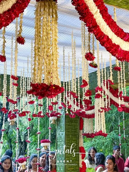 A wider view of the stunning floral ceiling, with guests gathered below. The vibrant colors and textures of the flowers create a festive and celebratory atmosphere.