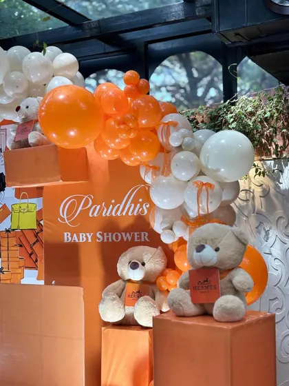 A close-up of the adorable teddy bears and the orange and white balloon garland.