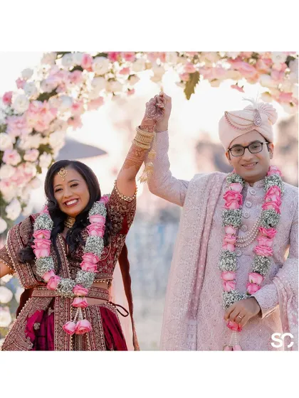 Hitesh and Aarishma's Varmala moment, a joyous celebration of their union with hands raised in triumph.