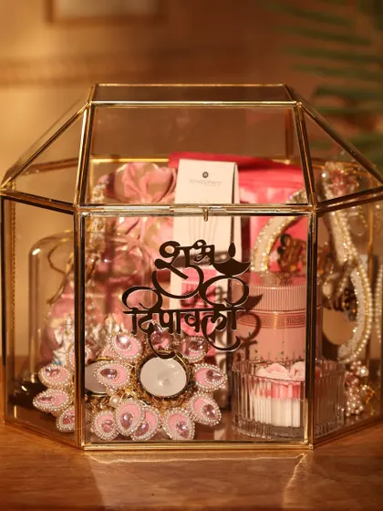 A closer look at the "Shubh Deepawali" glass terrarium hamper. The pink and gold theme inside creates a look of pure luxury.