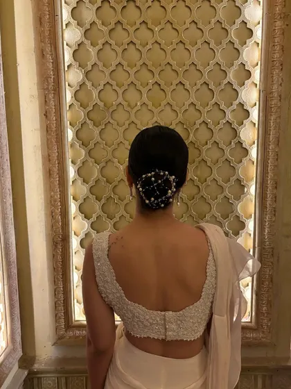 It's all in the details. For my Ambani wedding look, my hairstylist created this beautiful pearl-adorned bun, which perfectly complemented my all-white saree and added a touch of classic elegance.