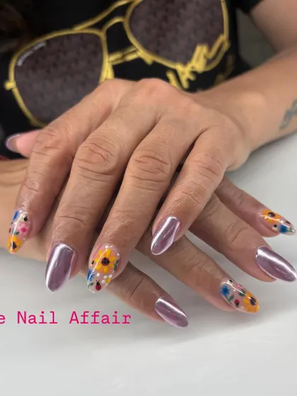 A creative and artistic set combining metallic chrome nails with accent nails featuring hand-painted abstract sunflowers on a clear base.