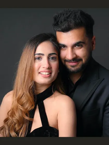 A classic and elegant couple portrait against a simple dark background. This timeless style focuses completely on the couple's connection and happiness.