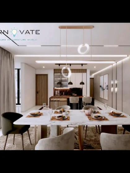 An open-plan luxury dining and kitchen concept. The design features a marble dining table, modern lighting, and a seamless flow between the two spaces.