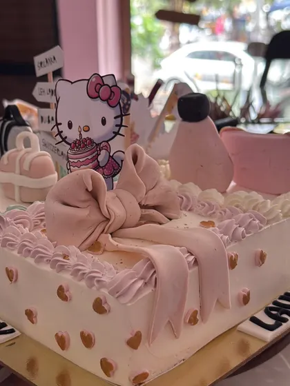 A cute Hello Kitty and a big pink bow add a touch of sweetness to this personalized hobby cake.