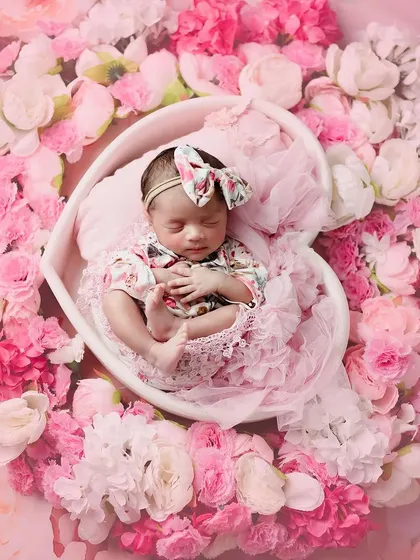 Just like a doll. This beautiful baby girl is surrounded by all sorts of pinks, creating a wonderfully floral and feminine portrait.
