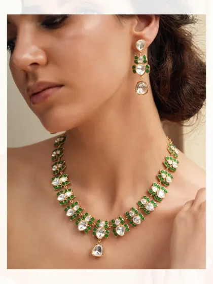 A delicate and elegant necklace with a single strand of floral motifs set with emeralds and polki diamonds.
