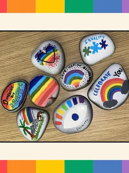 A close-up of pebbles painted with messages of equality and love. These small stones carry a big message and serve as a reminder of the company's commitment to D&I.