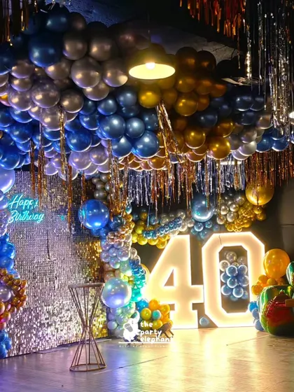 For this fabulous 40th birthday, I created a glamorous blue and gold balloon extravaganza. The decor featured a ceiling covered in balloons, a shimmering sequin wall, and large light-up marquee numbers for the big '40'.
