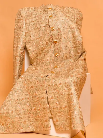 This sherwani jacket is adorned with beautiful golden and orange floral embroidery. It’s a radiant piece that brings a spark of color and artistry, perfect for celebrating in style.